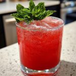 Iced Hibiscus Citrus Punch Mocktail – Floral hibiscus tea blended with citrus juices and fresh herbs.