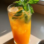 Peach Basil Refresher Mocktail – Juicy peach nectar and fragrant basil shaken with lemon juice and bubbles.