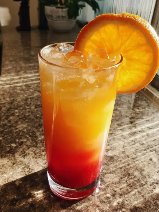 Sunrise Sparkler Mocktail – A vibrant layered drink featuring orange juice and grenadine for a sunrise effect.