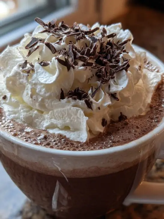 A festive mug of Christmas Irish Cream Coffee topped with whipped cream and chocolate shavings.