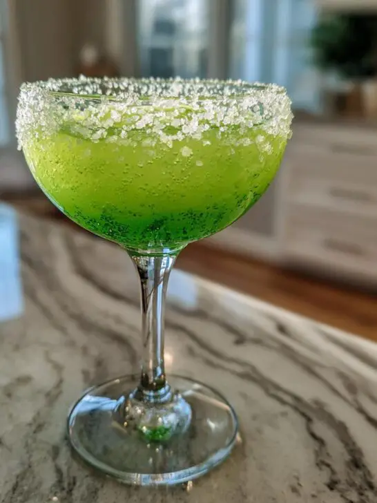 A vibrant green Halloween Poison Apple Margarita with a sugar-rimmed glass, perfect for spooky celebrations.