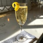 A sparkling New Year's Eve French 75 cocktail in a champagne flute, garnished with a lemon twist.