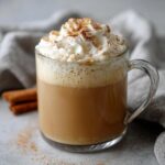 A close-up of a Thanksgiving Cinnamon Maple Latte topped with whipped cream and cinnamon.