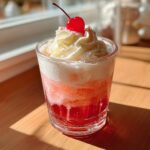 A festive Valentine’s Day Cherry Vanilla Cream Soda topped with whipped cream and a cherry.