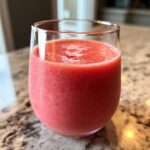 A close-up of a vibrant Valentine’s Day Pink Velvet Smoothie in a clear glass, showcasing its smooth texture and rich color.