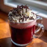 A festive Valentine’s Day Red Velvet Hot Chocolate topped with whipped cream and chocolate shavings.