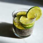 Glass of chia seed drink with lime slices, showcasing its Coconut Water Electrolyte Boost.