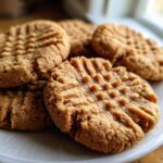 A close-up stack of freshly baked Ingredient Peanut Butter Cookies showing classic cross-hatch fork marks.
