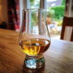 A glass of Bruichladdich Classic Laddie whisky on a wooden table, ready for review.