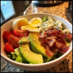 A vibrant Cobb Salad Recipe featuring fresh lettuce, sliced avocado, cherry tomatoes, hard-boiled eggs, crumbled blue cheese, and crispy bacon.