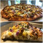 A close-up of a slice of homemade Jamaican Jerk Chicken Pizza, showing melted cheese, jerk chicken, pineapple, and red onion.