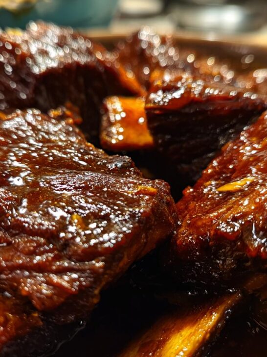 Close-up of succulent, glossy Instant Pot Short Ribs Recipe braised in a rich sauce.