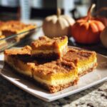 Close-up of delicious Pumpkin Cheesecake Bites with a pecan crust, layered and topped with crumb topping.