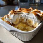Close-up of Classic Southern Banana Pudding topped with beautifully toasted meringue and visible banana slices.