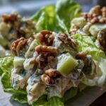 Close-up of Classic Waldorf Salad served in crisp lettuce cups, topped with walnuts and creamy dressing.
