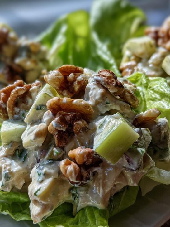 Close-up of Classic Waldorf Salad served in crisp lettuce cups, topped with walnuts and creamy dressing.