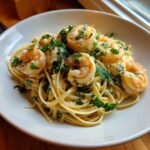 Close-up of creamy Gluten Free Coconut Lime Shrimp Pasta topped with seared shrimp and fresh parsley.