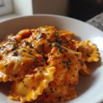 Close-up of Hubbys Date Night Vodka Ravioli coated in a rich, creamy orange sauce and sprinkled with parsley.