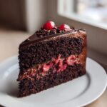 A decadent slice of Quick Cherry Chocolate Cake showing dark layers and cherry filling.