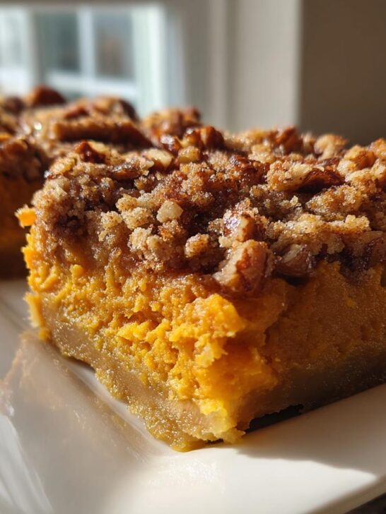Two squares of rich, orange Southern Maple Sweet Potato Casserole topped with a crunchy pecan streusel topping.