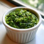 Close-up of vibrant, chunky Traditional Jamaican Green Seasoning in a small white ramekin.