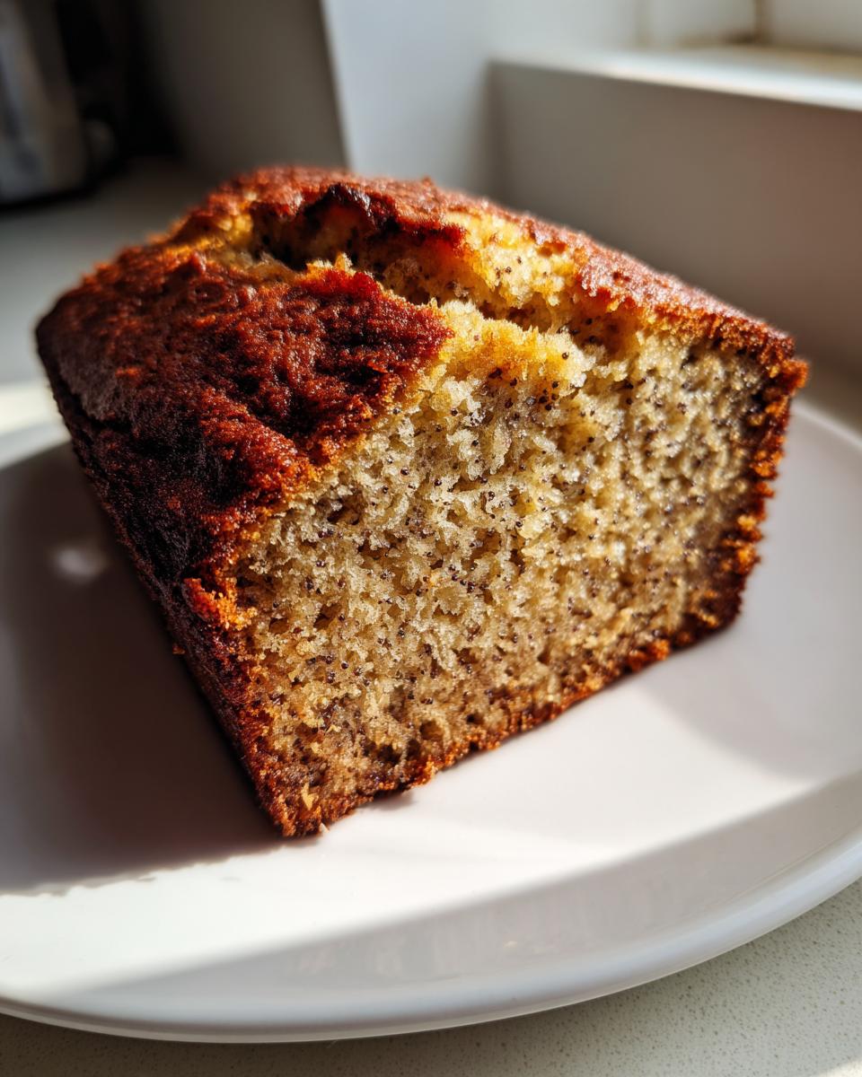 Close-up of a slice of Vegan Chia Seed Maple Banana Bread showing the moist crumb texture and dark chia seeds.