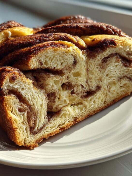 Cross-section slice of a rich Apple Cinnamon Babka showing soft, swirled layers of cinnamon filling.