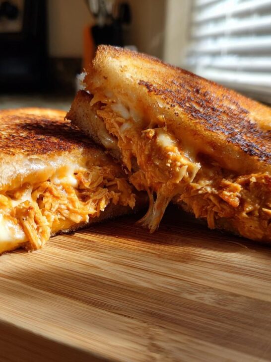 A halved Baked BBQ Chicken Grilled Cheese Dairy Free sandwich showing melted dairy-free cheese and saucy shredded chicken filling.