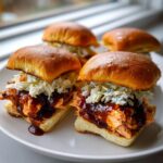 Four delicious Baked Salmon Sliders With BBQ Jerk Sauce topped with creamy coleslaw on brioche buns.