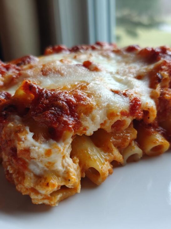 Close-up of a hearty slice of Baked Ziti Recipe topped with melted mozzarella and rich tomato sauce.