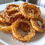 A close-up of crispy, golden Cheesy Onion Ring Chips piled high and dusted with grated cheese.