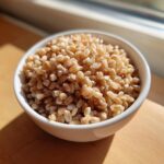 Close-up of cooked, plump grains in a white bowl, potentially serving as a Best Pearl Barley Substitute.