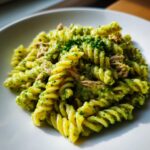 Close-up of creamy tuna pesto pasta made with fusilli, topped with fresh parsley.