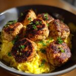 Six perfectly browned Greek Chicken Meatballs served over bright yellow lemon orzo and topped with fresh parsley.