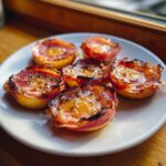 Close-up of five perfectly grilled apples wrapped in prosciutto and drizzled with honey.