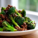 Close-up of bright green broccoli florets coated in a savory brown sauce with crumbled ground beef in a Ground Beef And Broccoli Stir Fry.