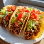 Three crispy tacos filled with seasoned Healthy Ground Turkey Tacos, shredded lettuce, and diced tomatoes.