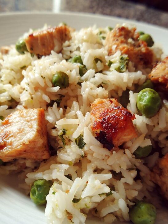 Close-up of a High Protein One Pot Dinner featuring white rice, seared chicken cubes, and bright green peas.