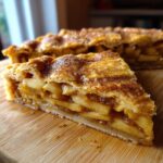 Close-up of a thick slice of Honeycrisp Apple Galette showing layered, spiced apples and flaky crust dusted with sugar.