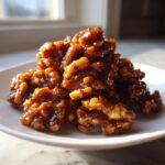 A pile of shiny, glazed walnuts ready for serving, showcasing the Maple Candied Walnut Recipe.