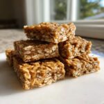 A stack of chewy No Bake Peanut Butter Oatmeal Bars made with rolled oats and a sticky binder.