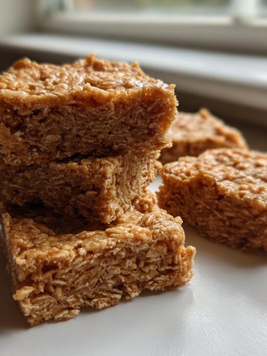 Close-up stack of chewy No Bake Peanut Butter Oatmeal Bars on a white plate.