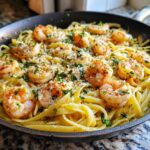 Close-up of One Pan Lemon Garlic Shrimp Pasta topped with Parmesan and fresh parsley in a black skillet.