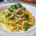 A close-up of creamy One Pot Lemon Garlic Parmesan Pasta topped with grated cheese and fresh parsley.