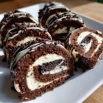 Close-up of several slices of rich chocolate Oreo Sushi Rolls filled with cream and cookie pieces.