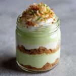 Close-up of a Tasty Coconut Key Lime Pie Parfait layered in a glass jar with graham cracker crust.