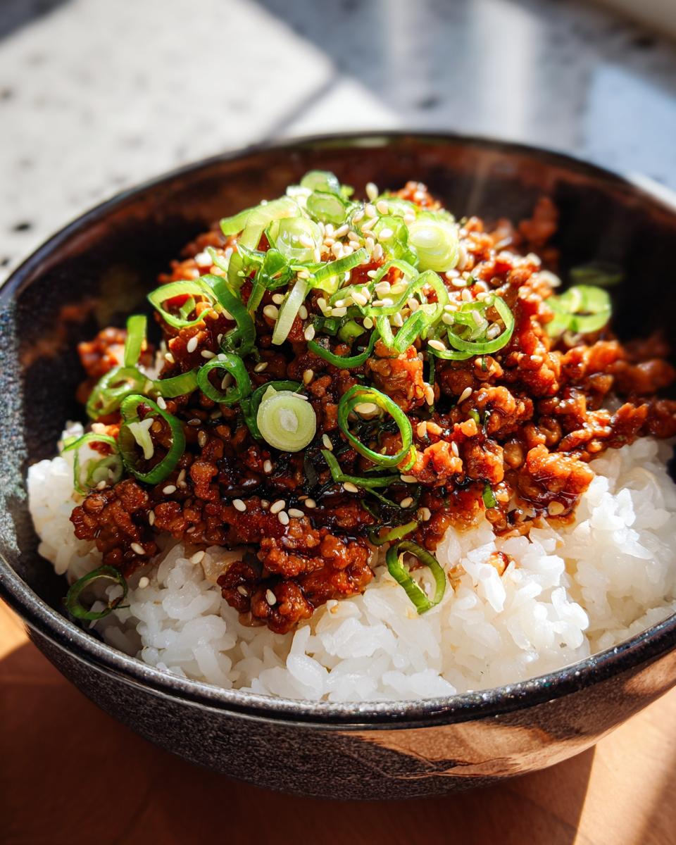 A close-up of a Teriyaki Turkey Rice Bowl featuring seasoned ground turkey over white rice, topped generously with sliced green onions and sesame seeds.