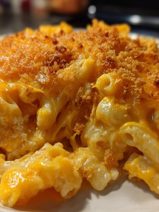 A close-up serving of creamy, cheesy Upgraded Mac And Cheese topped with a golden brown, crunchy breadcrumb crust.