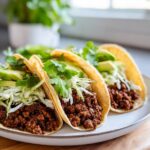 Three delicious Vegan Jamaican Jerk Walnut Tacos filled with spicy walnut mixture, shredded cabbage, avocado, and cilantro.