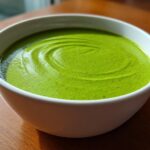 Close-up of a bowl filled with vibrant, creamy Green Goddess Soup Recipe, showing swirls on the surface.